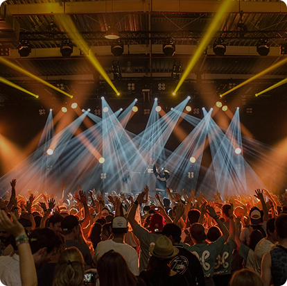 Crowd enjoying live music concert with stage lights